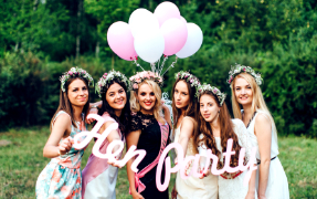 Six girls holding a hen party sign and balloons