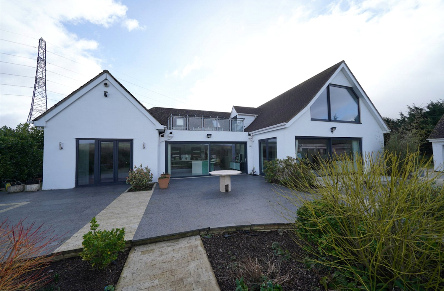 Large modern bungalow with two pitched roofs and bifold doors leading onto decking