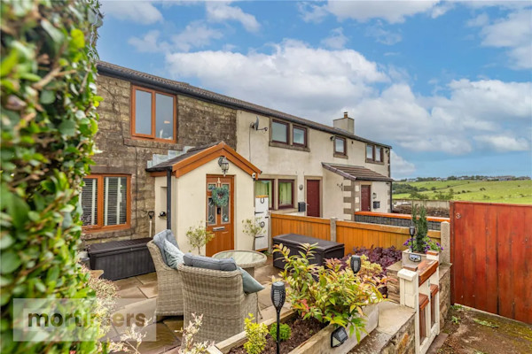 The exterior of a terraced cottage in Blackburn with views over rolling hills