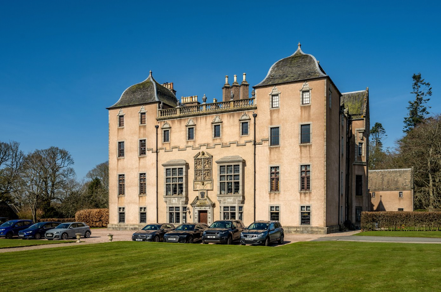 A grand mansion in Scotland with ornate windows and roof turrets