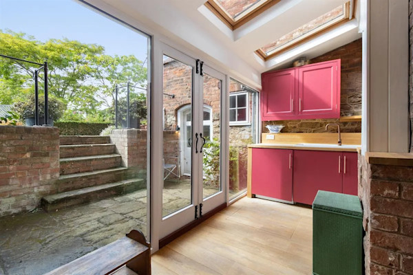The kitchen of a house with French doors showing the entrance to the annexe from the patio