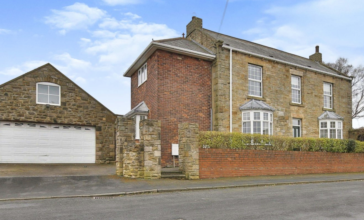 Yellow brick detached house with redbrick extension and garage to one side