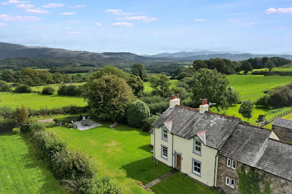 Aerial view of a house with acres of land set in the Lake District countryside