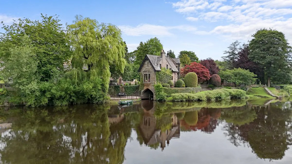 The exterior of a historic boathouse perched on the edge of a river in Lancaster
