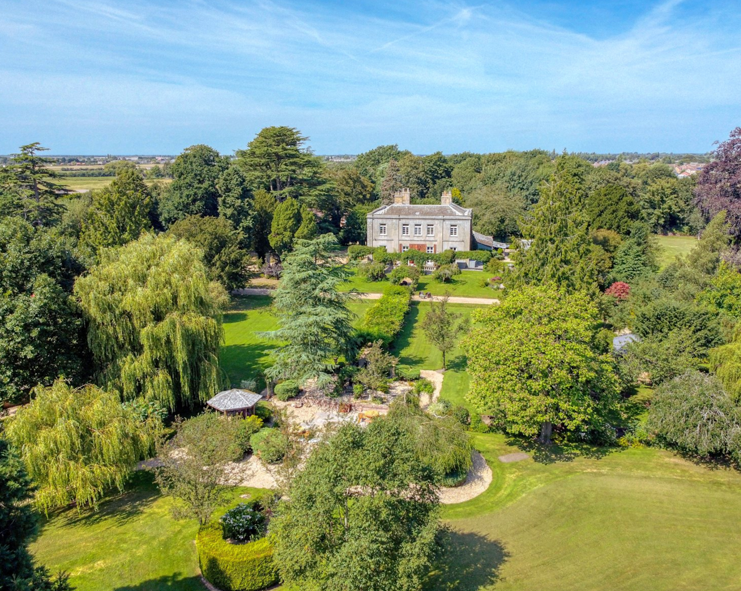 Stately home with mature gardens surrounding it