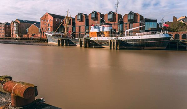 River Hull at high tide and beached obsolete fishing vessel.