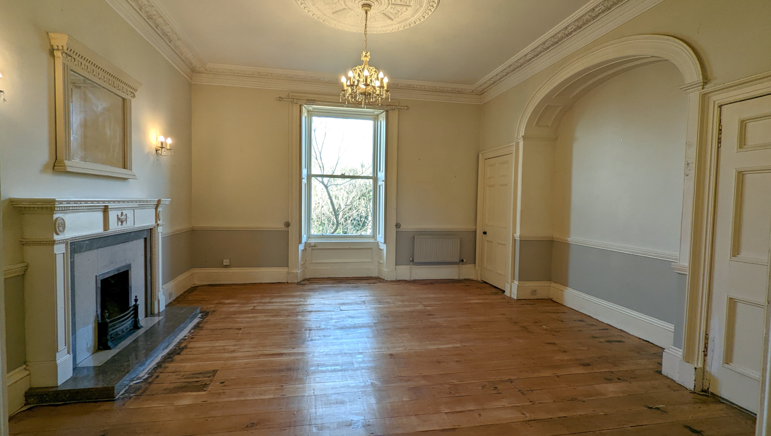 Inside a period property with original fireplace, windows, archway and dado rail mouldings