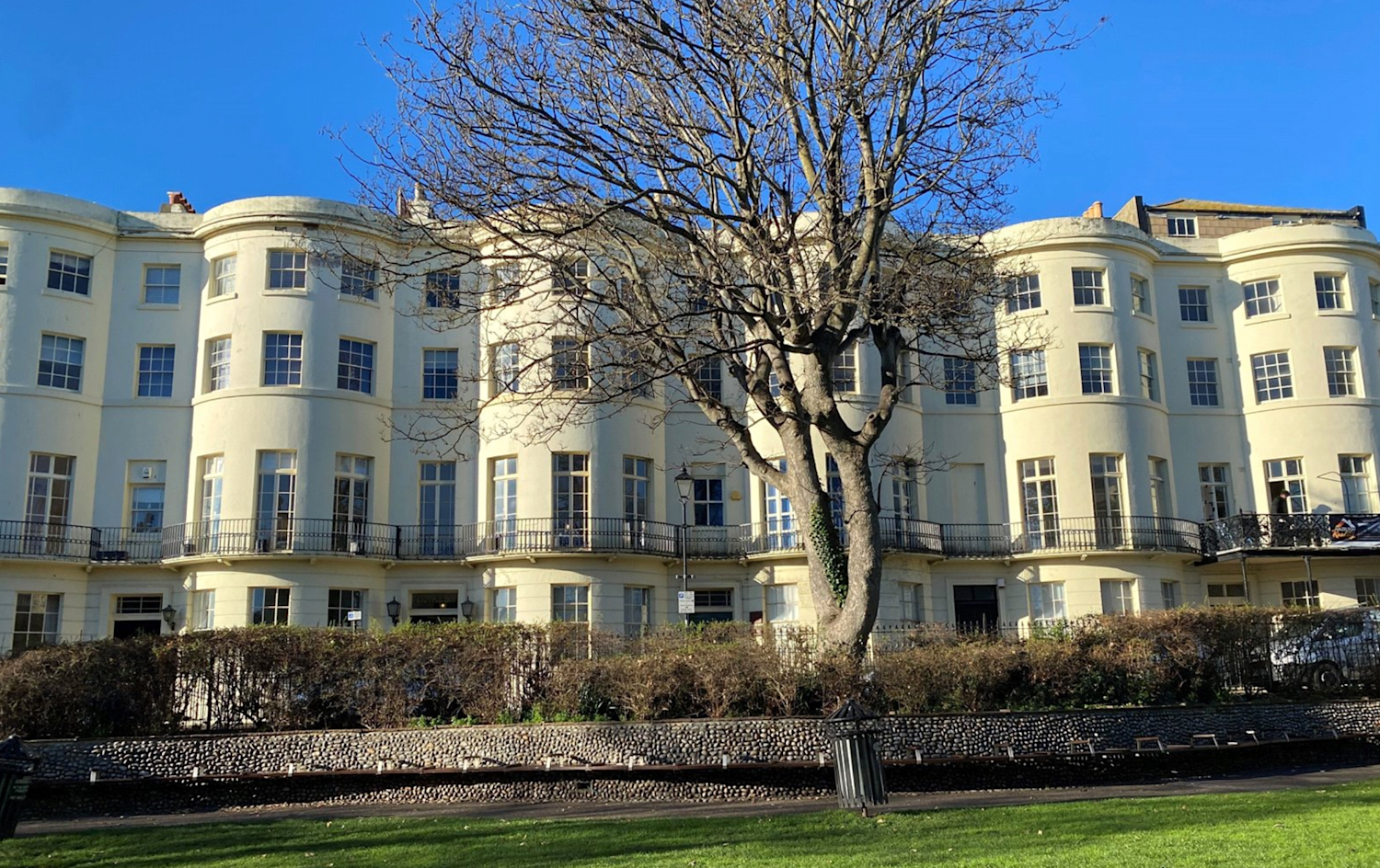 Curved frontages of white stucco Georgian terraced houses overlooking a square