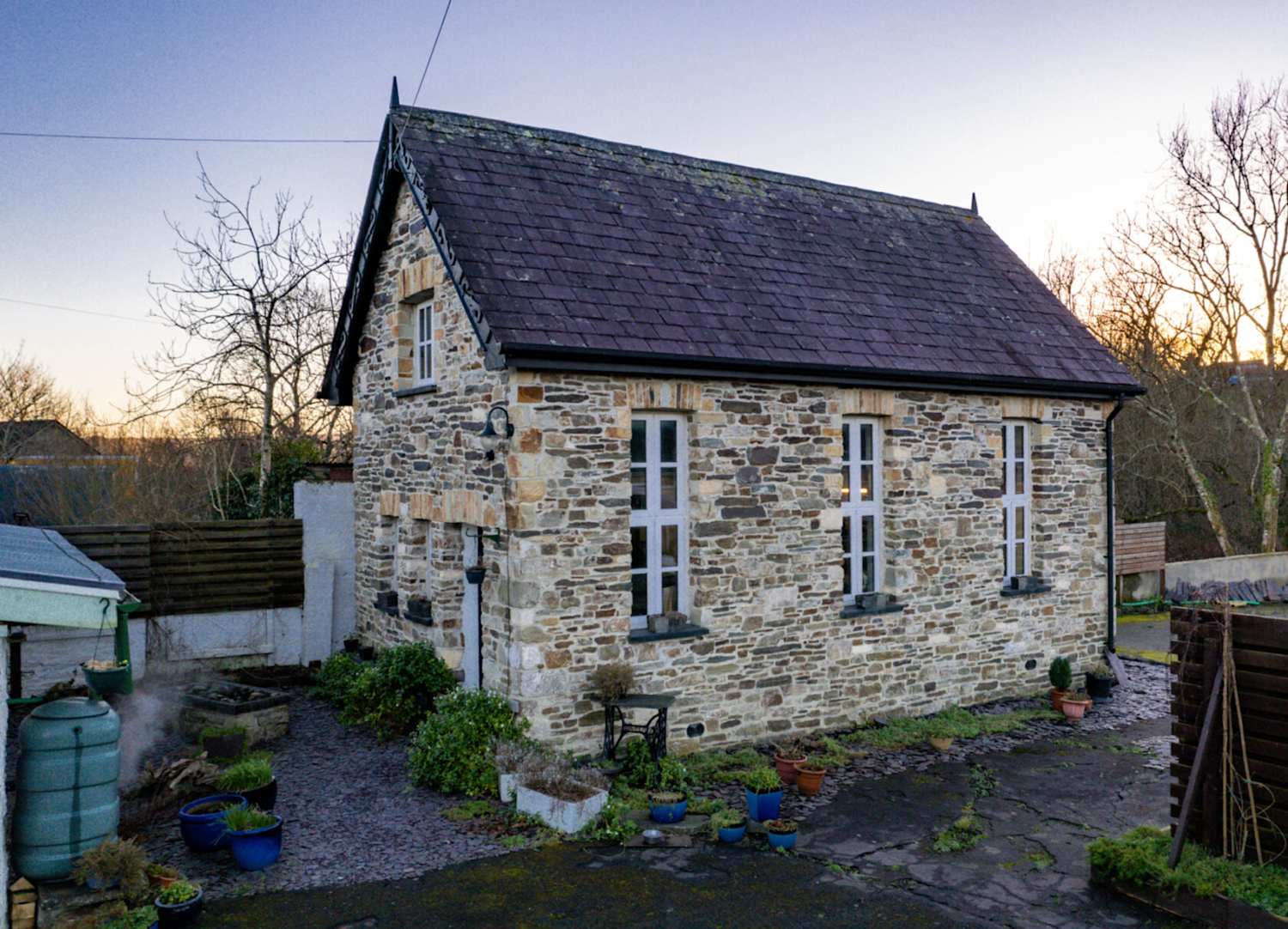 Stone built annexe in traditional style in Wales with slate roof and tall narrow windows