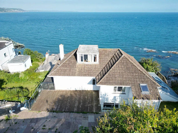 Aerial view of a house in Cornwall with the sea in the background