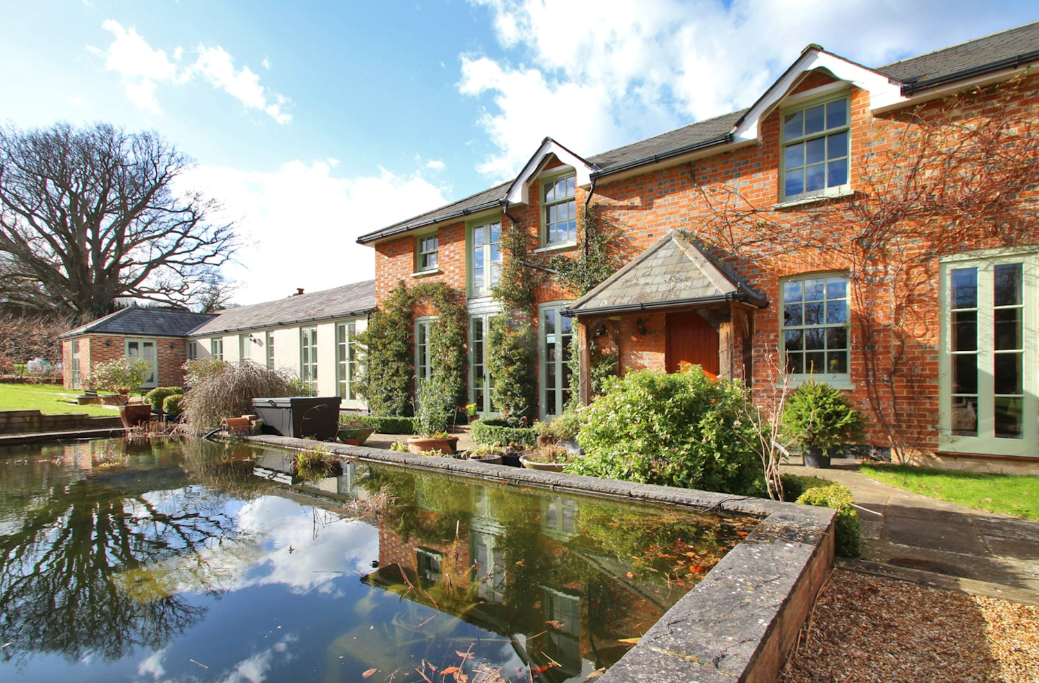 Annexe attached to a big red brick country house with fish pond
