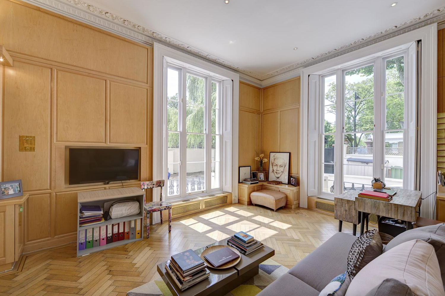 Modernised wood clad interior of a living room, with Georgian windows and herring bone flooring