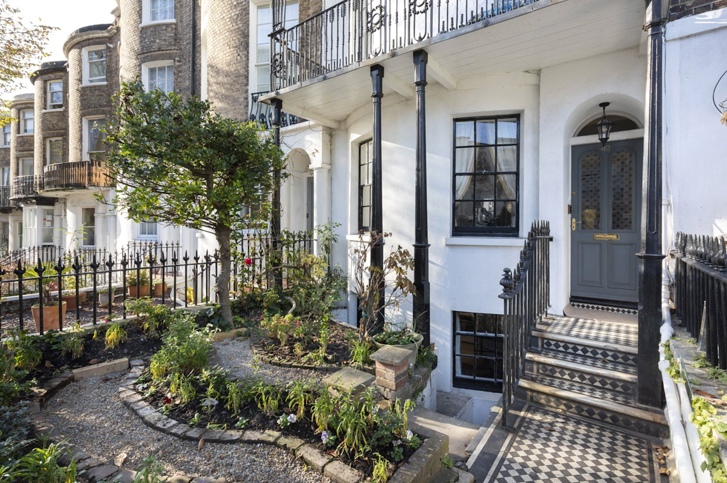 Entrance of Regency-Style terraced townhouse with black and white tiled pathway and wrought iron decorative porch