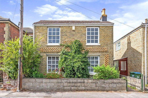 A well-presented detached cottage in Southampton with a symmetrical, four-window exterior and a low wall in front of the property
