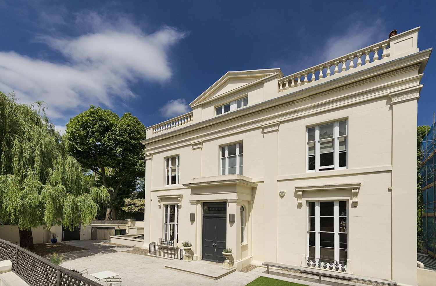 Detached white stucco house with a covered porch and Georgian-style windows