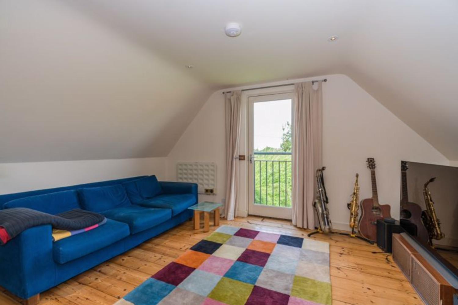 The living area of an annexe over a parking area with a modern interior and sloping ceilings