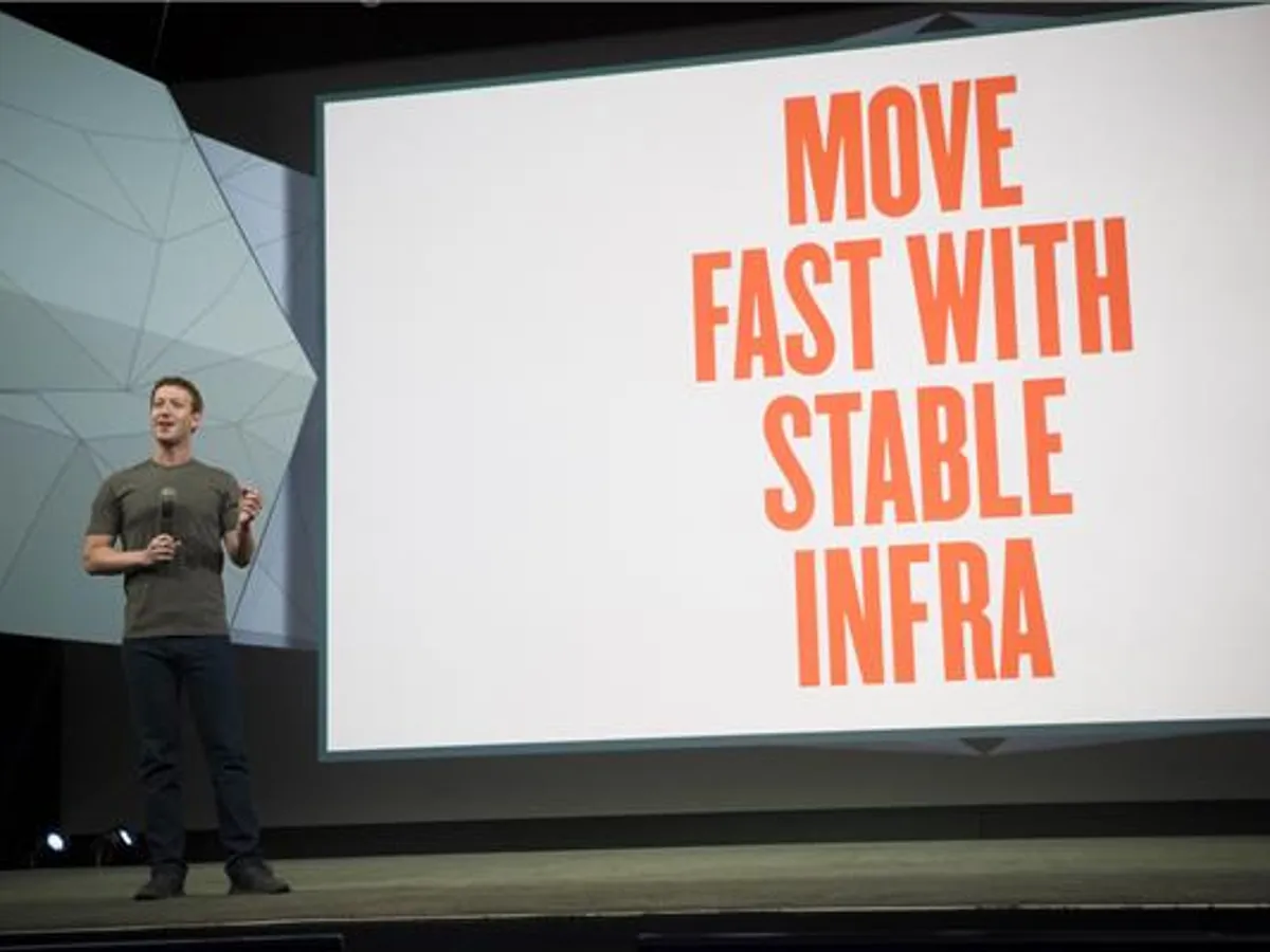 mark zuckerberg on stage with move fast and stable infra poster behind him