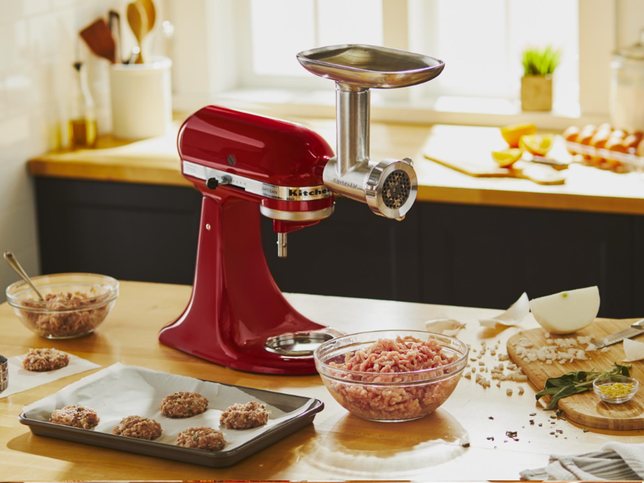 Stand-mixer-and-meat-grinder-and-sausage-stuffer-attachment-on-counter-with-meatballs-and-ingredients