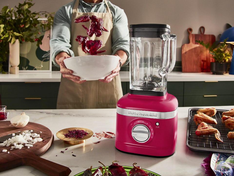 K400-Blender-hibiscus-colour-of-the-year-on-countertop-with-man-behind-shaking-ingredients