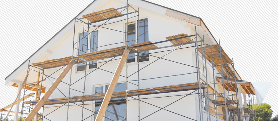 Modern house under construction with scaffolding on the outside.