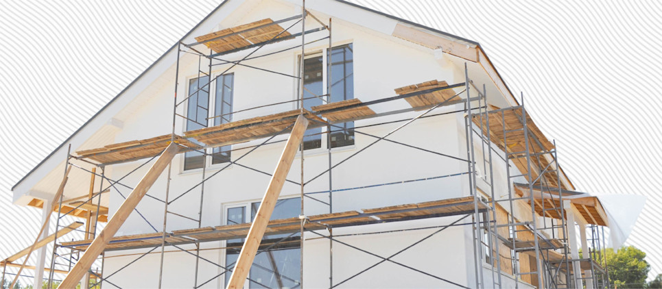 Modern house under construction with scaffolding on the outside. 