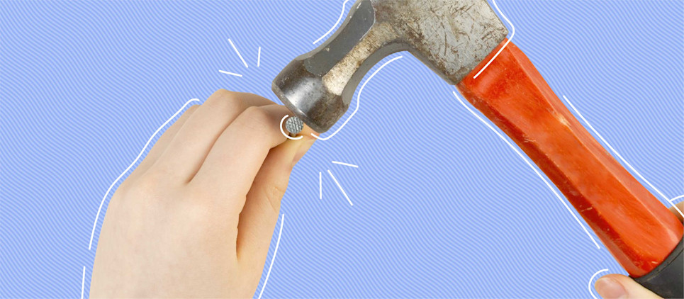 hands holding a red hammer with a nail in hand on a blue background