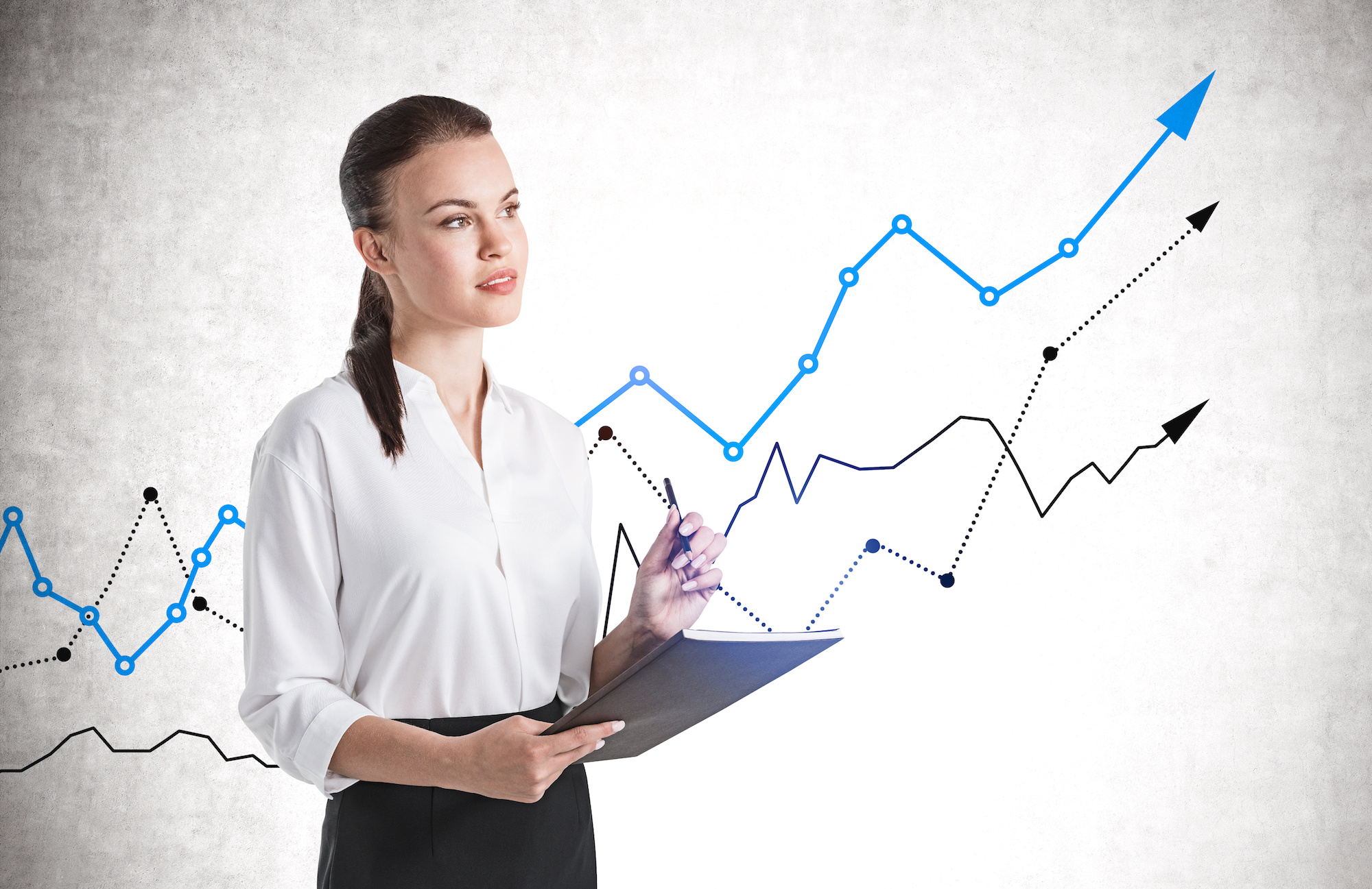 Woman stands in a front of a graph that shows an increase.