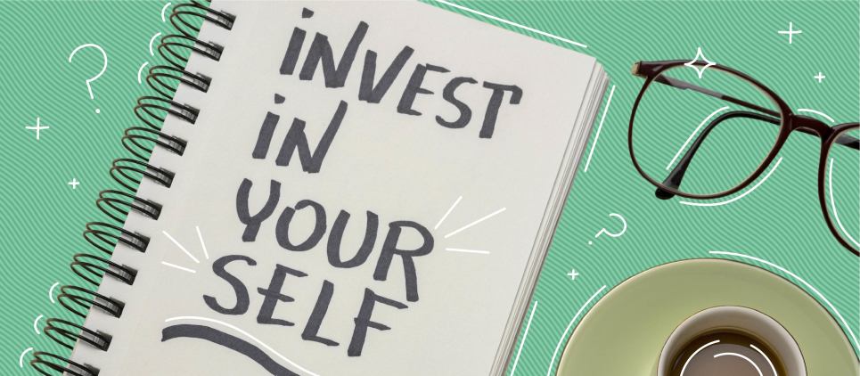 Notebook with the words "invest in yourself" written in it next to a pair of glasses.