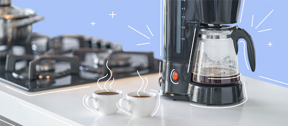 coffee maker with two cups of coffee on kitchen counter top next to stove
