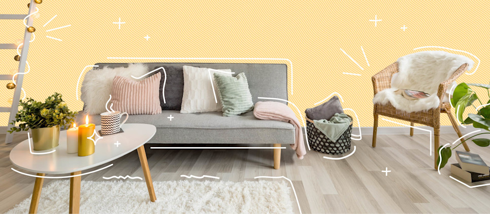 Cozy living room with rug, sheepskin, twinkle lights, a candle, couch and chair.