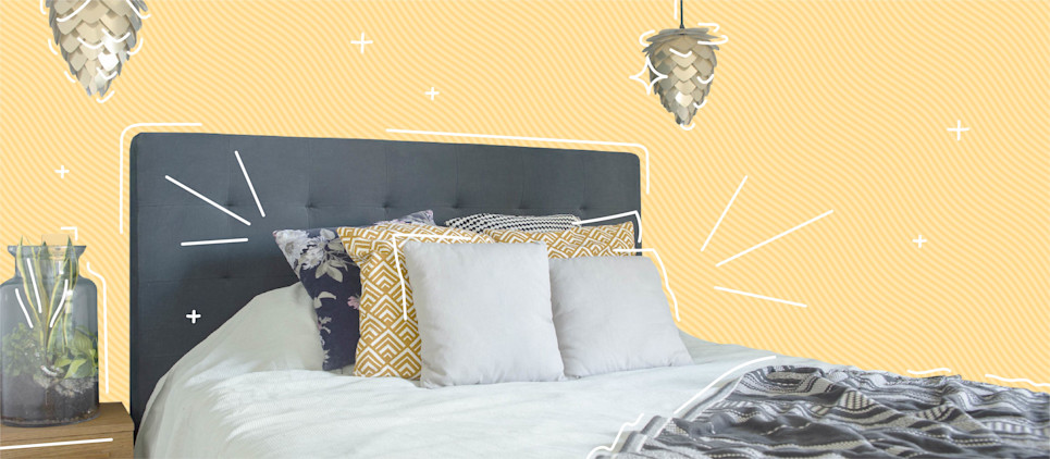 A small bedroom with pendant lights and a side table.