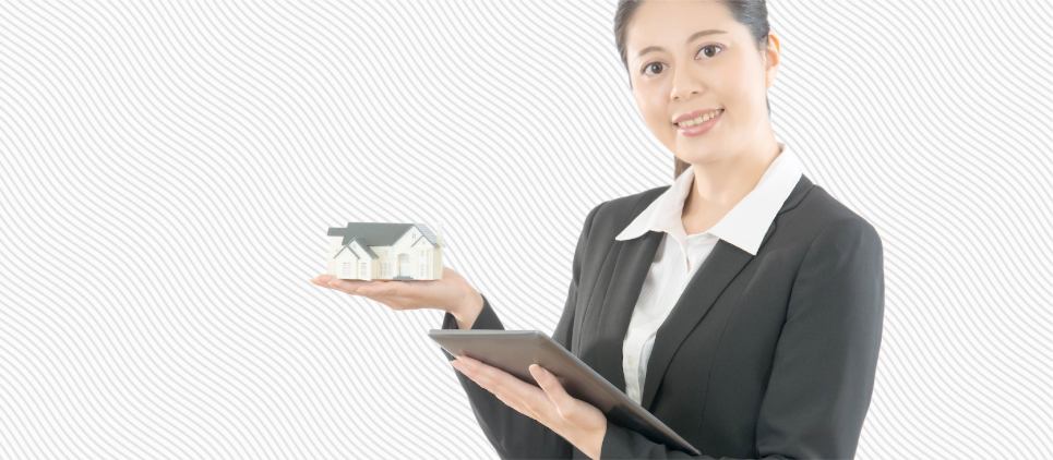 Woman holds a clipboard and a small figurine of a house. 