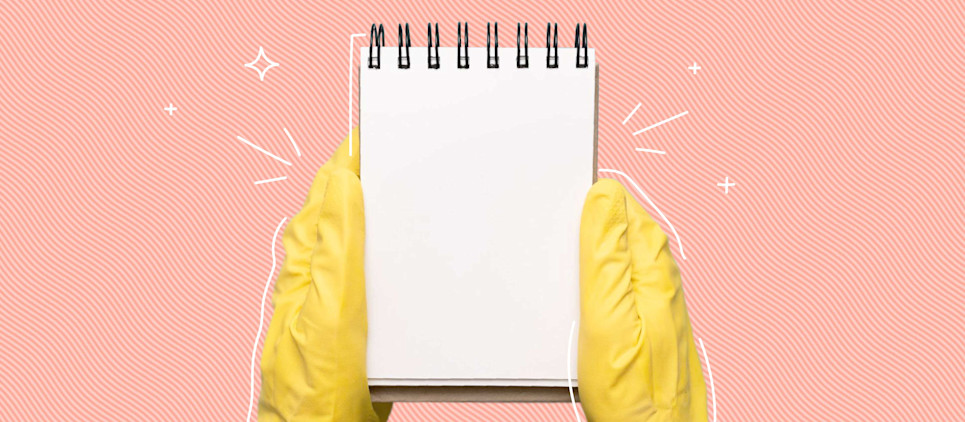 yellow rubber gloves holding note pad on pink background