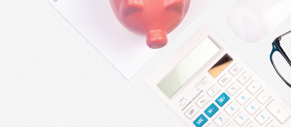 Piggy bank and calculator on a desk.