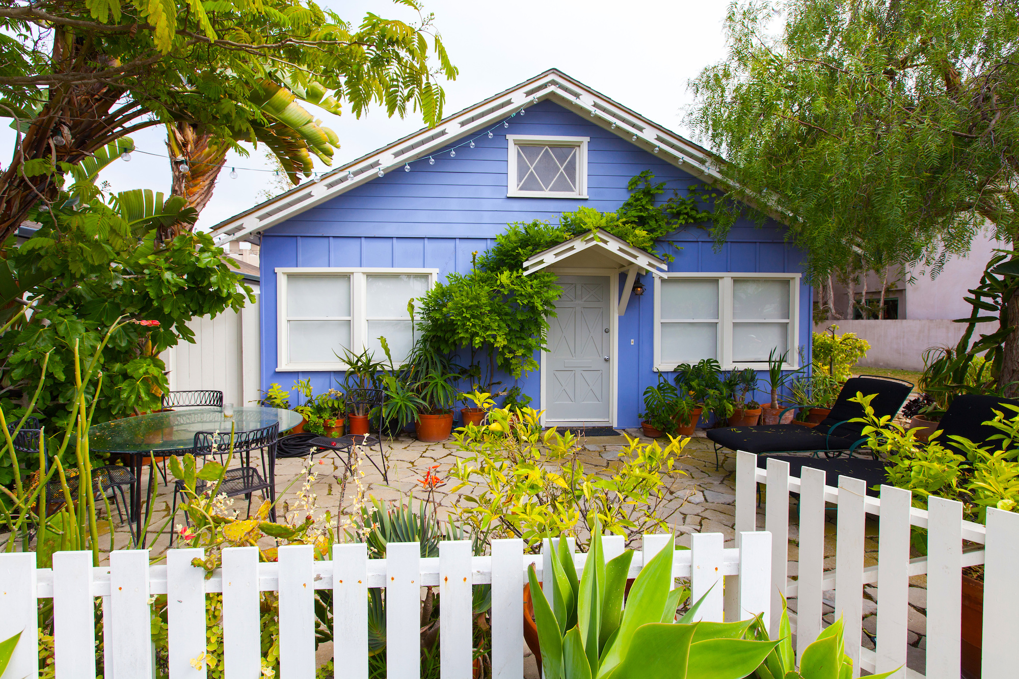 Blue bungalow house with a yard in front. 