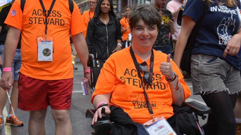 Pride steward in wheelchair giving a thumbs up