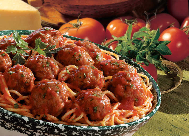 meatballs in tomato sauce on pasta in a green bowl