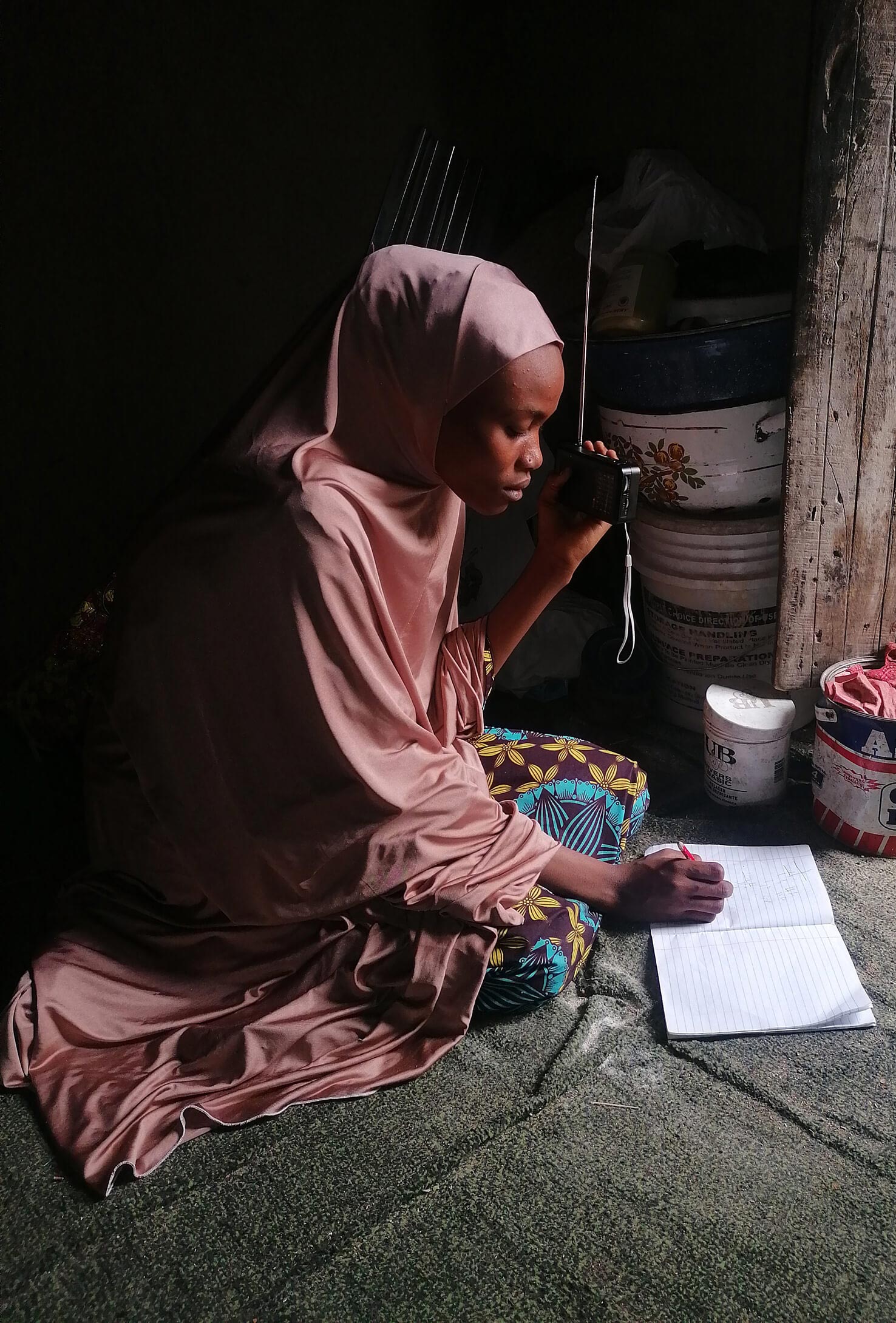 A Nigerian girl listening to radio lessons produced by Malala Fund Education Champions.