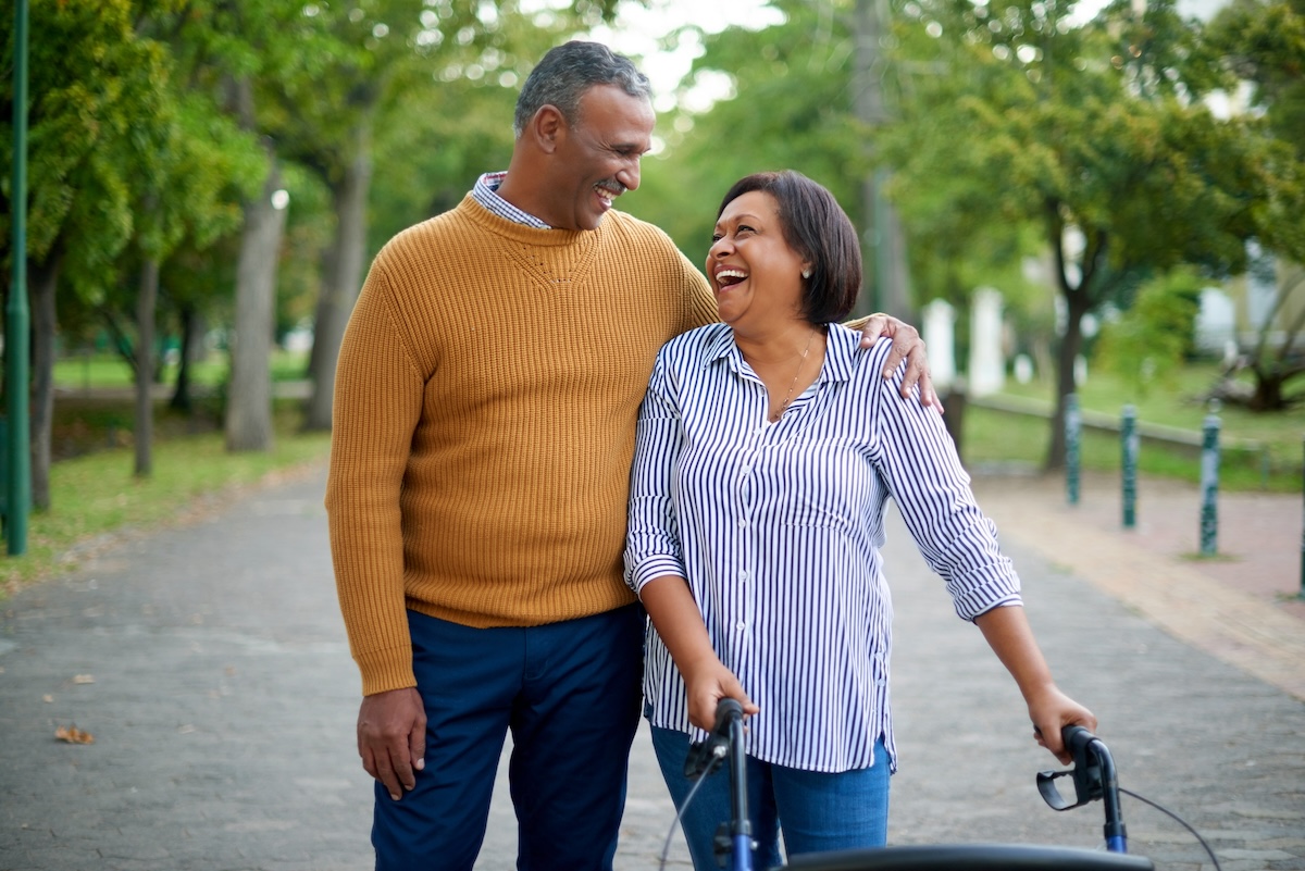 Mature man and woman married couple outside at a park on a walk discussing their HealthEquity HSA.