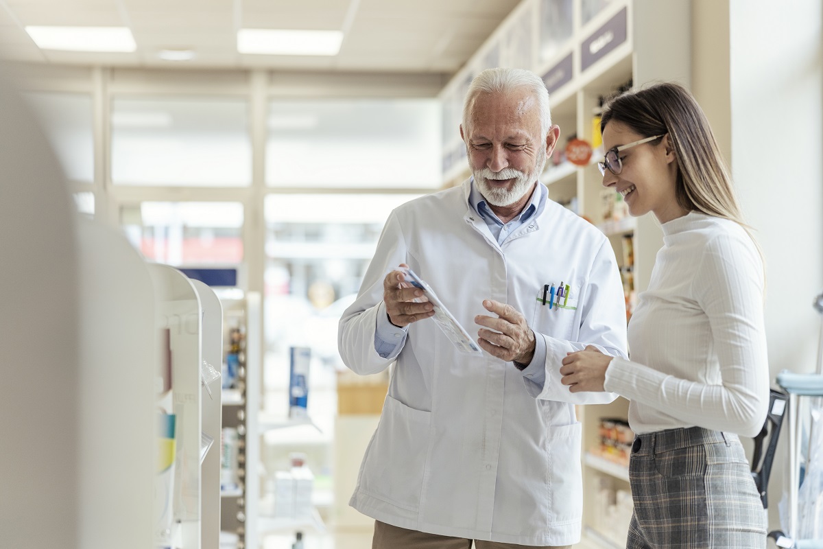 Young professional woman speaks to the pharmacist and finds ways to maximize her HSA benefits.