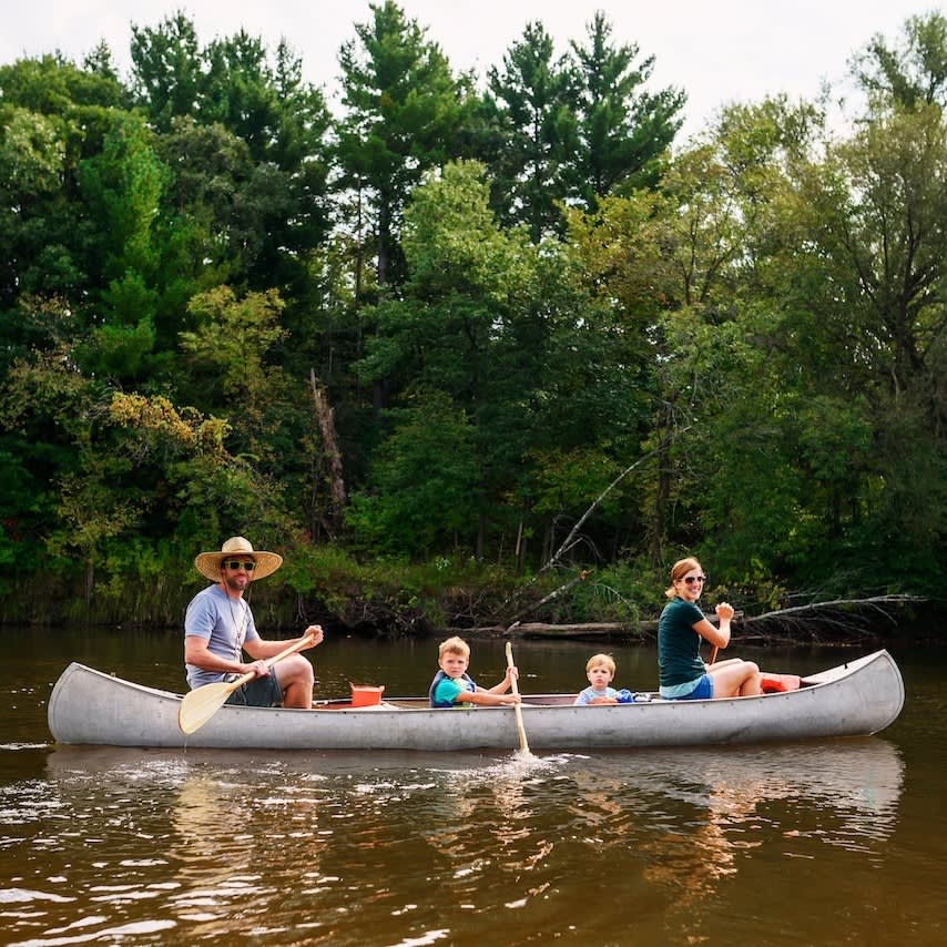 Family Canoeing - Mobile - A family canoes together on a calm river