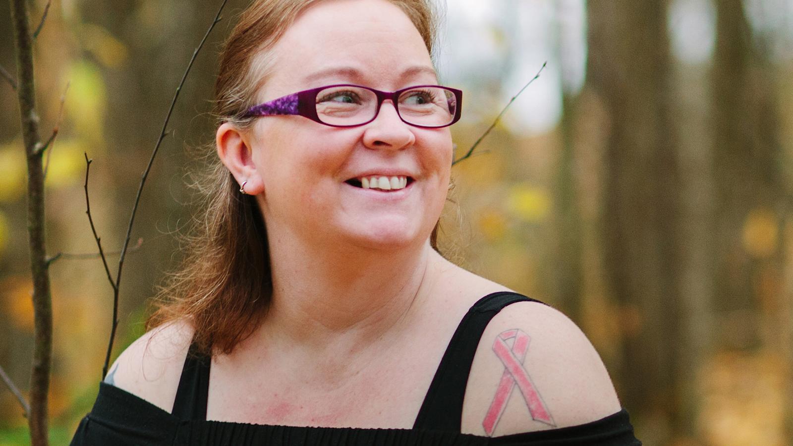 Kirsi Paajanen otti käteensä Roosa nauha -tatuoinnin.