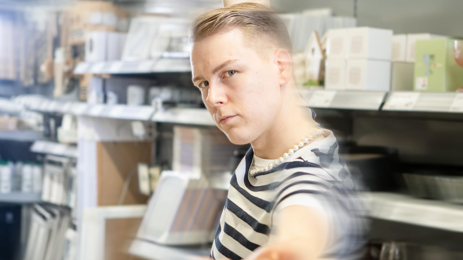 Valtteri poseeraa Prisman hyllyjen välissä.