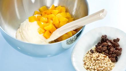 Valuta persikoista liemi. Sekoita rahkan joukkoon persikat, mantelirouhe ja rusinat.