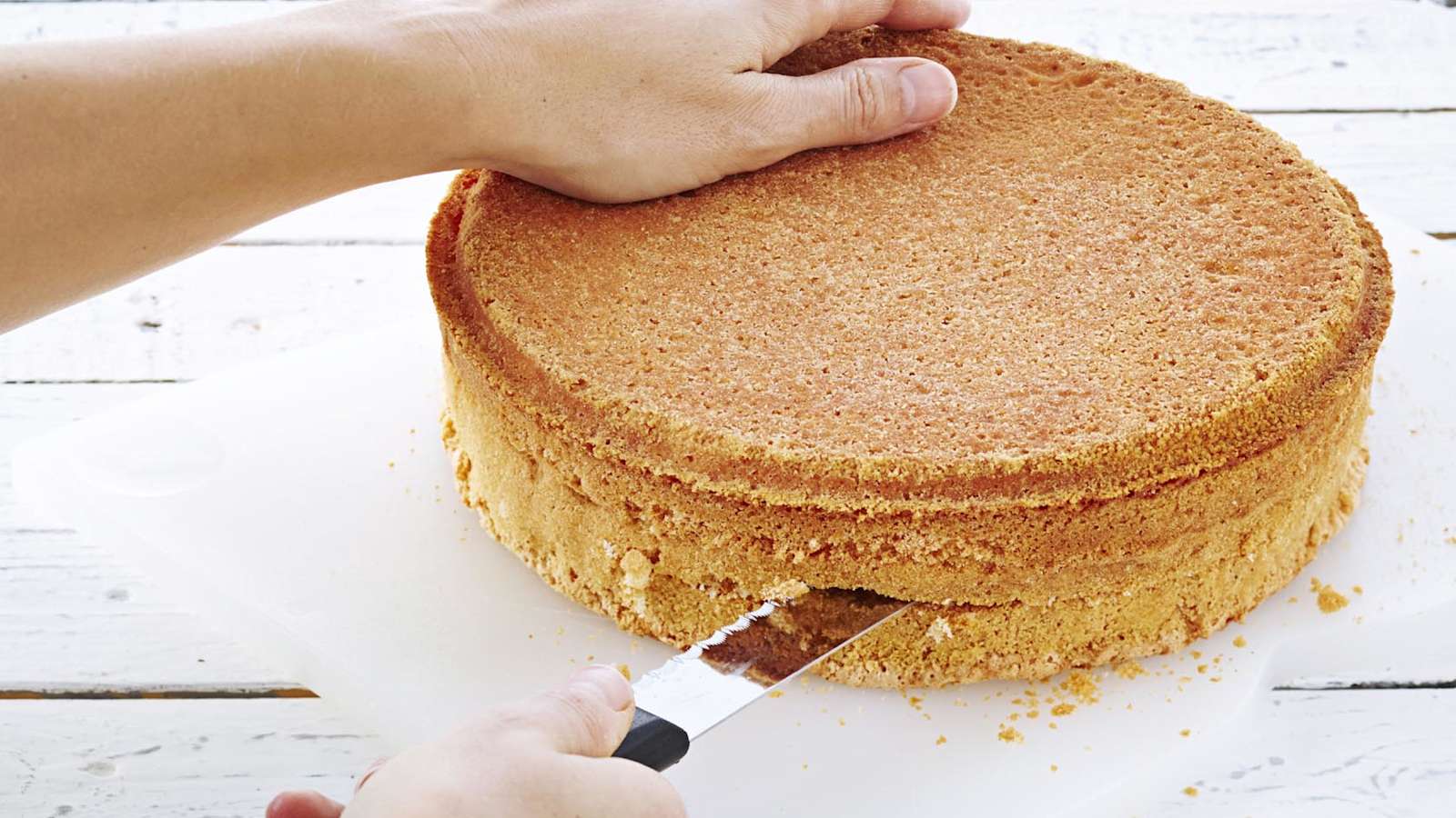 Kumoa hetken seisonut kakku ritilälle ja anna jäähtyä kunnolla. Leikkaa pohja kolmeen osaan.