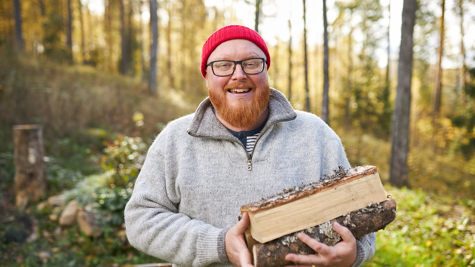 Roy Norro kantaa sylissään halkoja