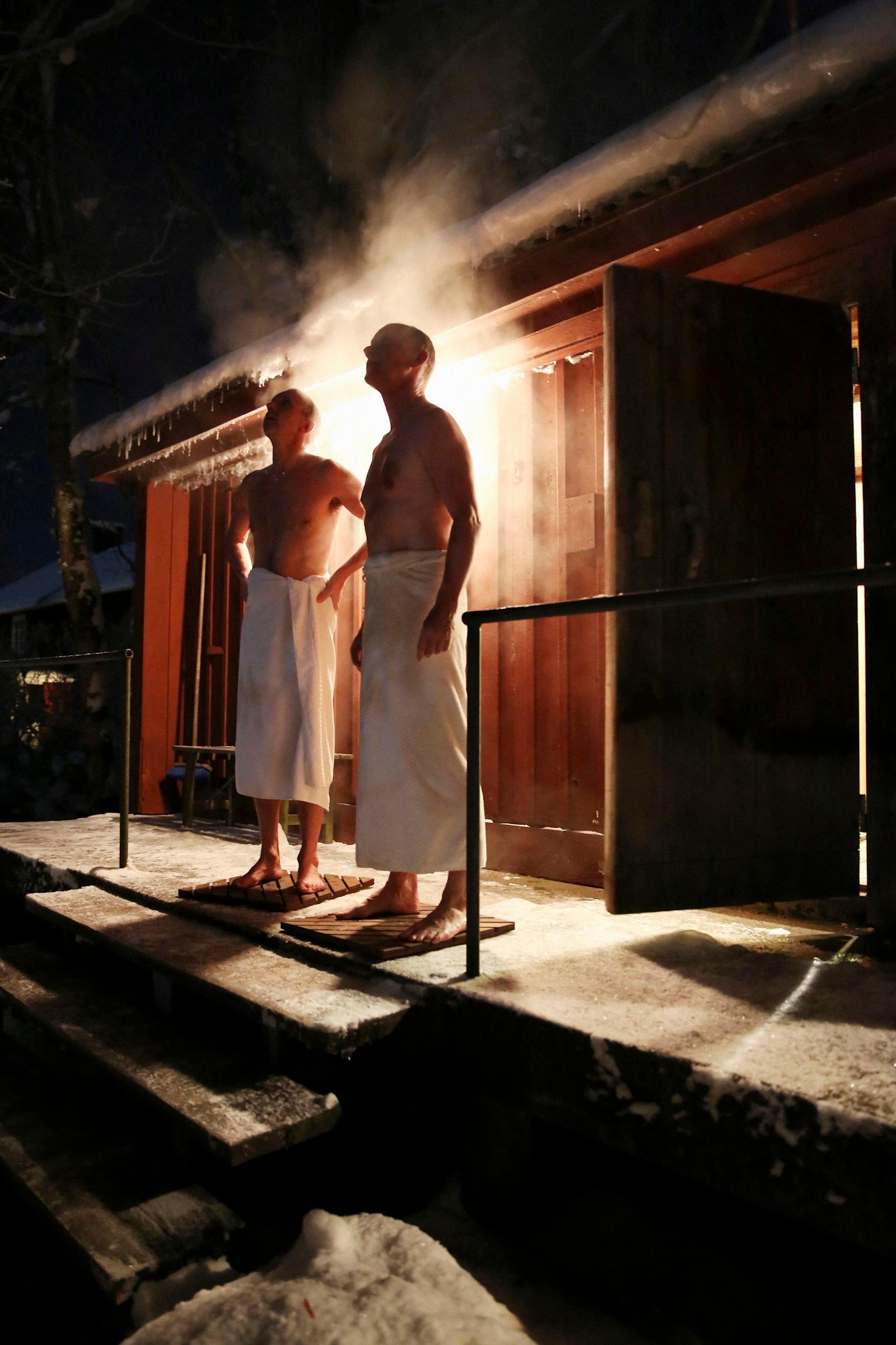 Kaksi miestä vilvottelee saunan jälkeen ulkona.