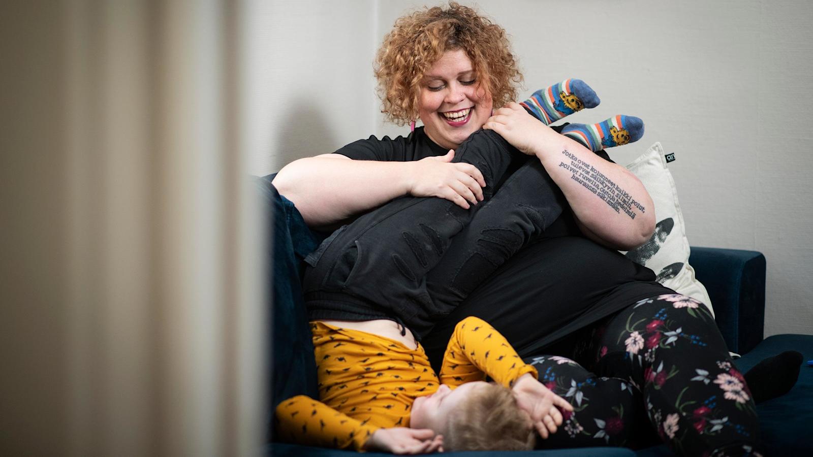 Hanna Parviainen leikkii poikansa kanssa sohvalla.