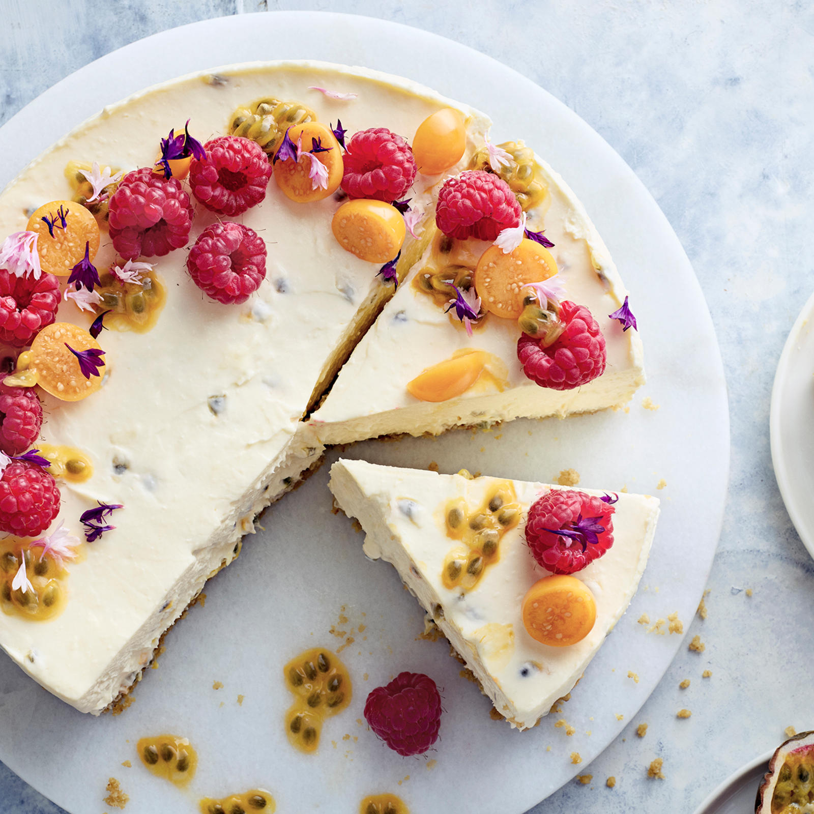 Valkosuklaa-passionjuustokakku, passiohedelmää ja vadelmia