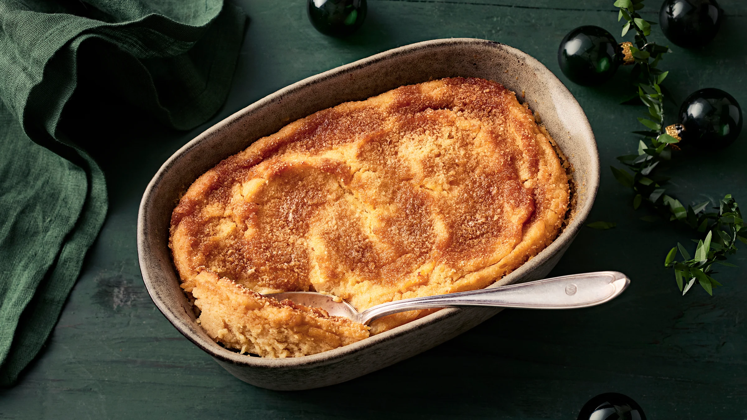 Lanttulaatikko soseesta. Pöydällä joulukoristeita ja liina.